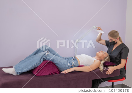 Caucasian woman on eyelash extension procedure. Caucasian woman on eyelash extension procedure. 105430178