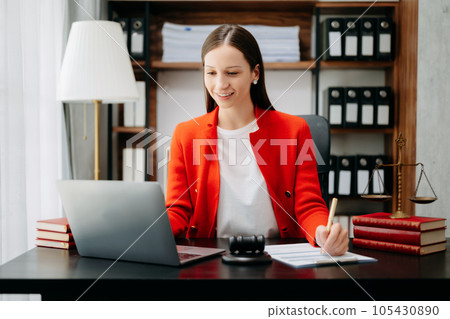 justice and law concept. Female judge in a courtroom  the gavel, working with smart phone and laptop and digital tablet computer on black  table 105430890