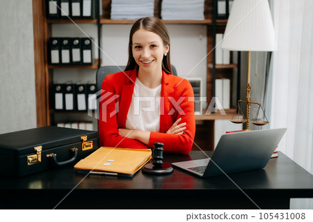 justice and law concept. Female judge in a courtroom  the gavel, working with smart phone and laptop and digital tablet computer on black  table 105431008