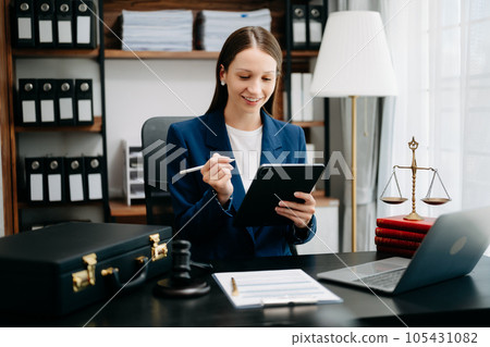 justice and law concept. Female judge in a courtroom the gavel, working with smart phone and laptop and digital tablet computer on black table justice and law concept. Female judge in a courtroom the gavel, working with smart phone and laptop and digital tablet computer on black table 105431082