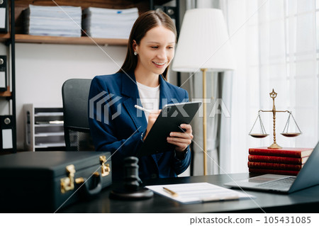 justice and law concept. Female judge in a courtroom  the gavel, working with smart phone and laptop and digital tablet computer on black  table 105431085