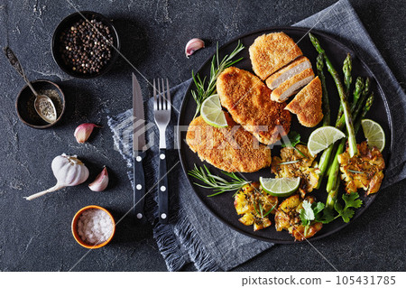 fried chicken breasts with asparagus and potatoes 105431785