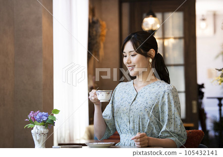 在咖啡館的一個少婦飲用的咖啡 在咖啡館的一個少婦飲用的咖啡 105432141