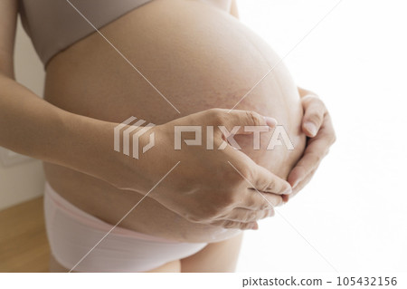 孕婦把手放在有妊娠紋和中線的肚子上 孕婦把手放在有妊娠紋和中線的肚子上 105432156