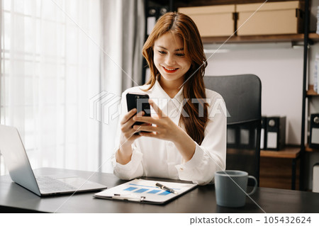 Confident business expert attractive smiling young woman holding digital tablet  on desk in creative office. 105432624