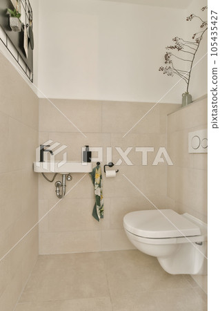 a bathroom with a toilet and flowers on the wall next to the toilet in the photo is taken from above 105435427