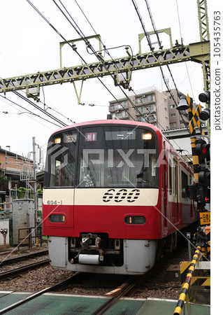 Keihin Express train approaching a railroad crossing 105435763