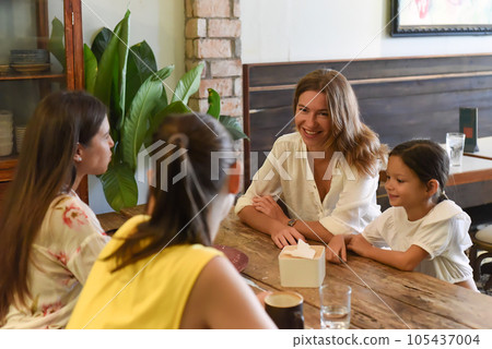 Female best friends talking and eating in a cafe Female best friends talking and eating in a cafe 105437004