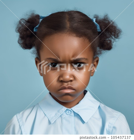 Portrait of an angry little African girl with curly brown hair. Closeup face of a furious African American child on a blue background. Unhappy kid with no expression in blue shirt looking at camera. Portrait of an angry little African girl with curly brown hair. Closeup face of a furious African American child on a blue background. Unhappy kid with no expression in blue shirt looking at camera. 105437137