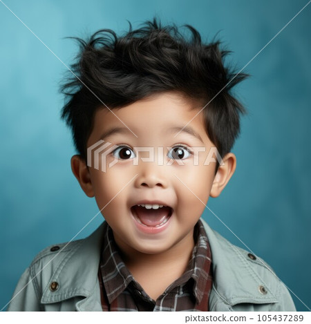 Portrait of a surprised little Asian boy with open mouth and big eyes. Closeup face of a shocked Chinese kid on a blue background looking at camera . Front view of amazed child in casual clothes. 105437289