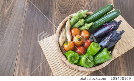 Image of summer vegetables ・Put water in a wooden bucket and add vegetables | Cucumbers, eggplants, green peppers, mini tomatoes, okra, ginger Image of summer vegetables ・Put water in a wooden bucket and add vegetables | Cucumbers, eggplants, green peppers, mini tomatoes, okra, ginger 105438169