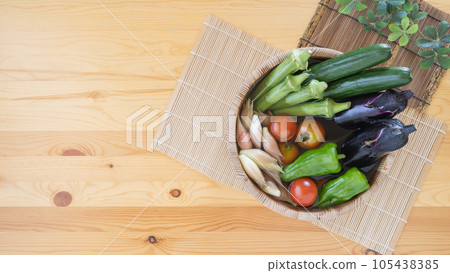 Image of summer vegetables ・Put water in a wooden bucket and add vegetables | Cucumbers, eggplants, green peppers, mini tomatoes, okra, ginger 105438385