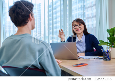 Guy student at therapy meeting with psychologist, mentor in college office 105439200
