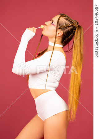 Sexy woman face. Sweet bite. Young Beautiful model with lollipop. 105440687