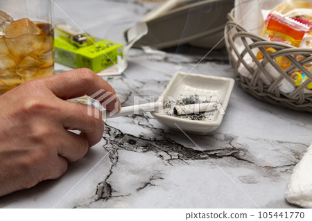 一個男人在小吃櫃檯抽煙的手 一個男人在小吃櫃檯抽煙的手 105441770