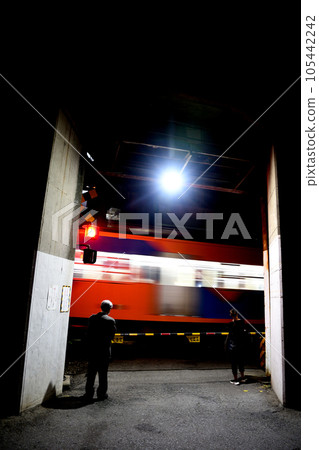 A train passes through a railroad crossing at night 105442242