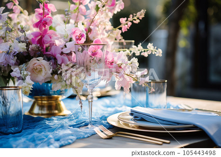 Flower table decorations for wedding dinner. Wedding table set for holiday, event, party, wedding reception in outdoor restaurant. Pink and blue with gold wedding table setting. AI generated 105443498