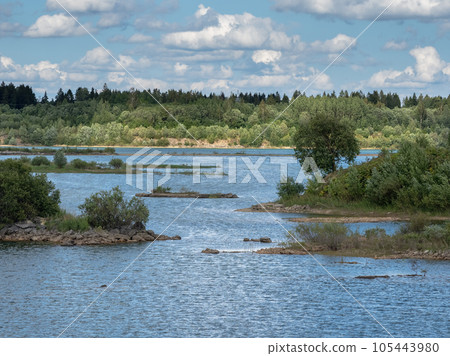 Big water lagoon. Island in the middle of the river With trees covered. An old quarry flooded with water. Big water lagoon. Island in the middle of the river With trees covered. An old quarry flooded with water. 105443980