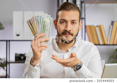 Young business man showing money dollar cash gives to you wages salary, satisfied with good work 105444003