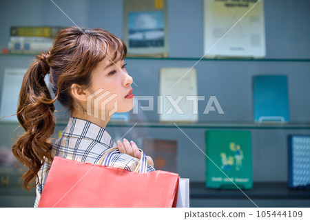 A woman holding a shopping bag A woman holding a shopping bag 105444109