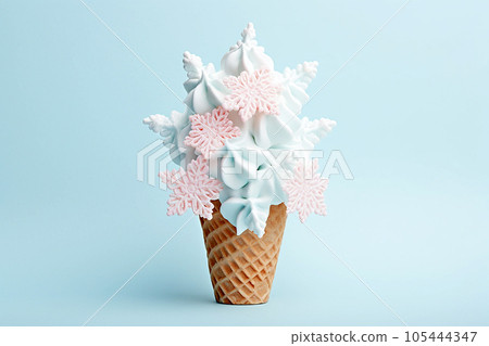 Ice cream cone with Christmas decoration snowflake greeting card. Minimal Christmas or New Year winter holidays concept. Waffle cone and snow flakes, summer meets winter, sweet dessert Ice cream cone with Christmas decoration snowflake greeting card. Minimal Christmas or New Year winter holidays concept. Waffle cone and snow flakes, summer meets winter, sweet dessert 105444347