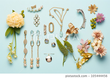 Jewelry with flowers flat lay, top view on pastel background. Stylish golden bijouterie with stones and gems. Women's accessories. Sales, shopping, spring and nature concept 105444456