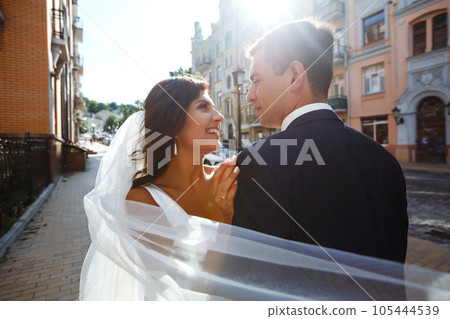 Bride and groom kisses tenderly in the shadow of a flying veil. Together. Wedding. Love. Bride and groom kisses tenderly in the shadow of a flying veil. Together. Wedding. Love. 105444539