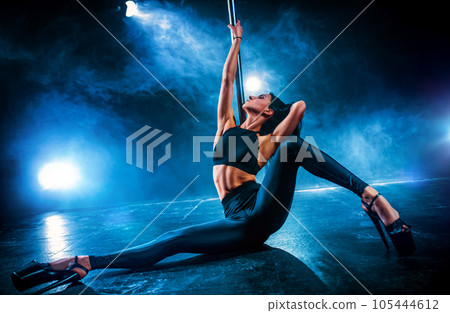 Young woman pole dancing 105444612