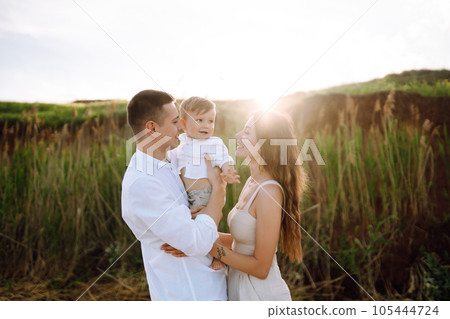 Cheerful young family with little baby boy spending time together on the beach. Cheerful young family with little baby boy spending time together on the beach. 105444724