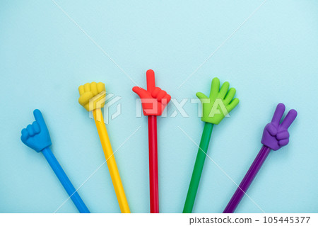 Colorful school erasers in the form of various gestures on colored pencils on a blue background. The concept of nonverbal communication, the expression and transmission of thoughts using symbols Colorful school erasers in the form of various gestures on colored pencils on a blue background. The concept of nonverbal communication, the expression and transmission of thoughts using symbols 105445377