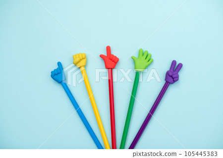Colorful school erasers in the form of various gestures on colored pencils on a blue background. The concept of nonverbal communication, the expression and transmission of thoughts using symbols 105445383