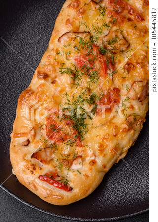 Delicious oven fresh flatbread pizza with cheese, tomatoes, sausage, salt and spices Delicious oven fresh flatbread pizza with cheese, tomatoes, sausage, salt and spices 105445812