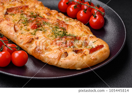Delicious oven fresh flatbread pizza with cheese, tomatoes, sausage, salt and spices Delicious oven fresh flatbread pizza with cheese, tomatoes, sausage, salt and spices 105445814