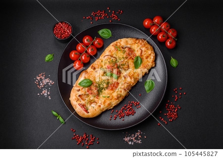 Delicious oven fresh flatbread pizza with cheese, tomatoes, sausage, salt and spices 105445827