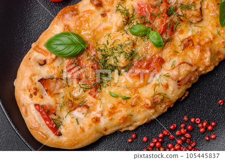 Delicious oven fresh flatbread pizza with cheese, tomatoes, sausage, salt and spices 105445837