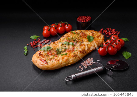 Delicious oven fresh flatbread pizza with cheese, tomatoes, sausage, salt and spices 105445843