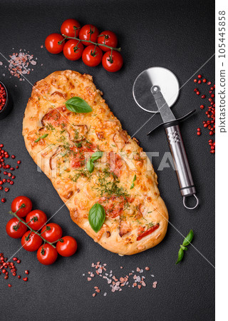 Delicious oven fresh flatbread pizza with cheese, tomatoes, sausage, salt and spices 105445858