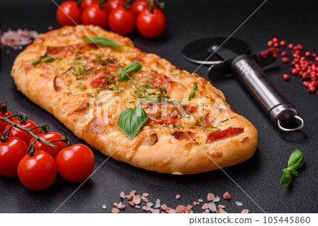 Delicious oven fresh flatbread pizza with cheese, tomatoes, sausage, salt and spices 105445860