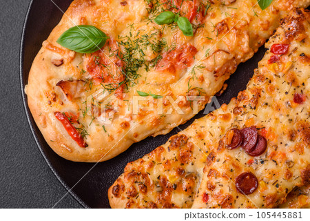 Delicious oven fresh flatbread pizza with cheese, tomatoes, sausage, salt and spices Delicious oven fresh flatbread pizza with cheese, tomatoes, sausage, salt and spices 105445881