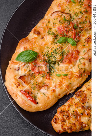 Delicious oven fresh flatbread pizza with cheese, tomatoes, sausage, salt and spices 105445883