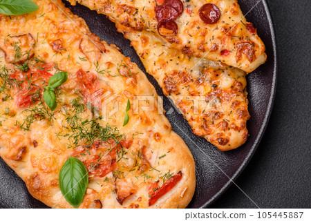 Delicious oven fresh flatbread pizza with cheese, tomatoes, sausage, salt and spices 105445887