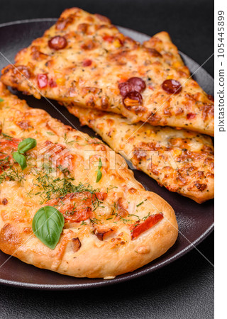 Delicious oven fresh flatbread pizza with cheese, tomatoes, sausage, salt and spices Delicious oven fresh flatbread pizza with cheese, tomatoes, sausage, salt and spices 105445899