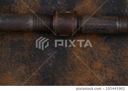 Rusty valve pipes on rusty metal wall 105445902
