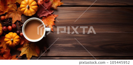 Mug of coffee and autumn leaves with orange pumpkin on wooden table. Autumn drink concept. 105445952