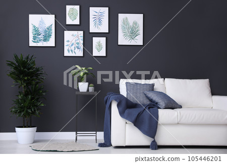Beautiful paintings of leaves on black wall in living room interior 105446201