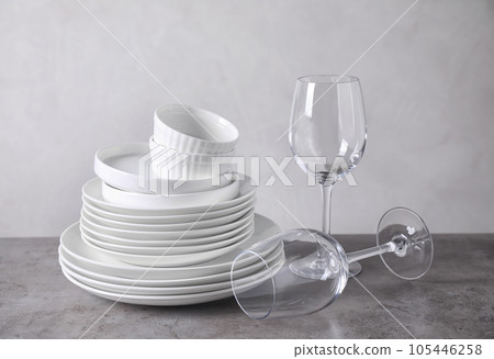 Set of clean dishware on grey table 105446258
