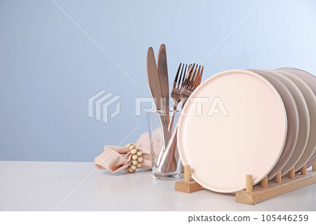 Set of clean tableware on light table. Space for text Set of clean tableware on light table. Space for text 105446259