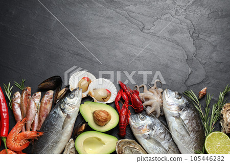 Fresh fish and different seafood on black table, flat lay. Space for text Fresh fish and different seafood on black table, flat lay. Space for text 105446282