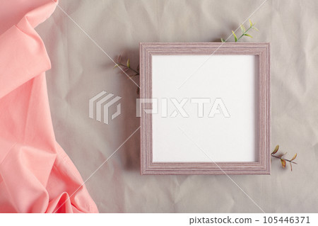 Mockup empty photo frame and branches on green cotton fabric top view 105446371