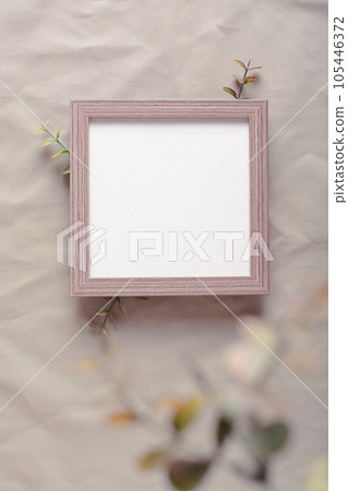 Mockup blank photo frame and branches on green cotton fabric top and vertical view 105446372